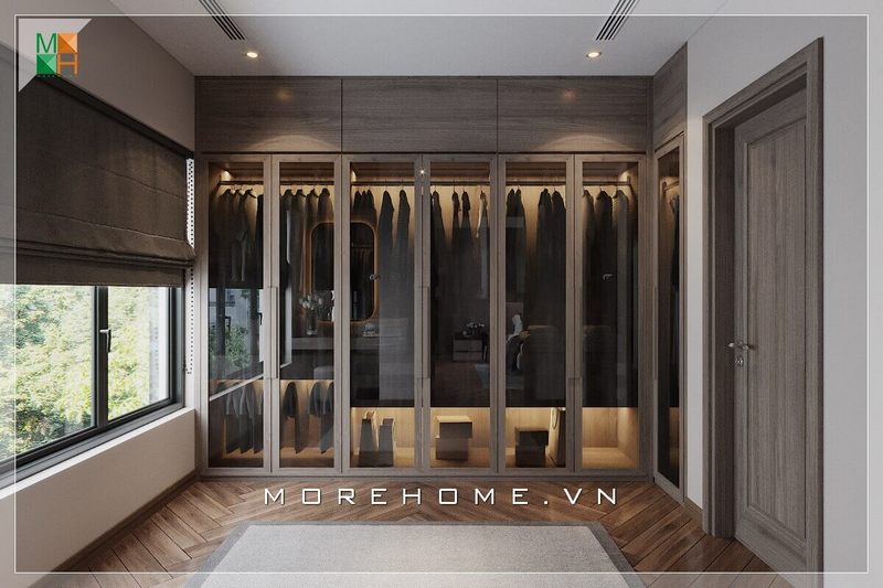.
Hệ tủ quần áo kịch trần chất liệu gỗ chủ đạo, cửa kính cánh mở, sàn lát gỗ kiểu xương cá, rèm cửa sổ đều được trang trí bằng màu nâu trầm giúp tôn lên vẻ đẹp thanh lịch và tao nhã của mẫu phòng thay đồ này.